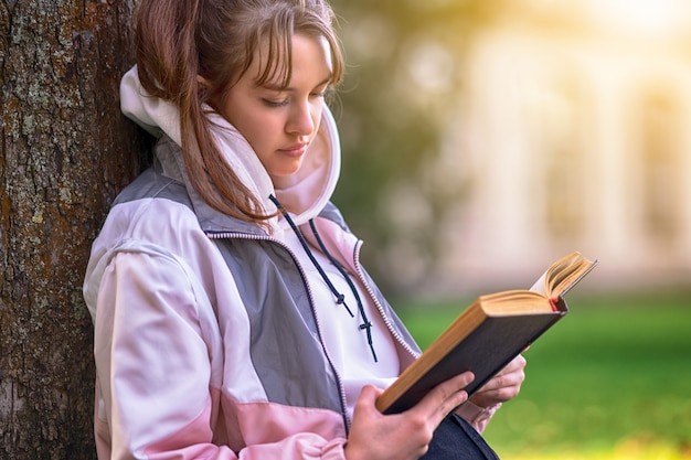 Bastante joven adolescente sentado leyendo