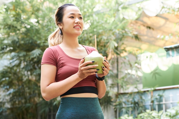 Bastante joven con cóctel de coco