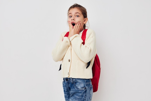 Bastante joven colegiala con mochila roja posando antecedentes aislados