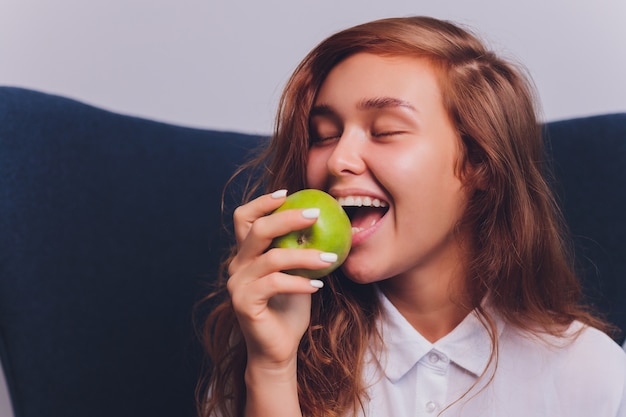 Bastante joven comiendo una manzana