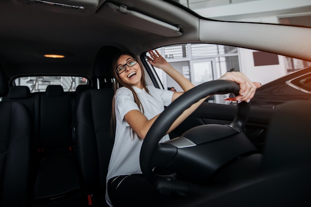 Bastante joven conduciendo un coche nuevo.