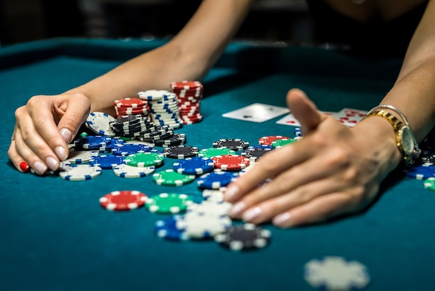 Bastante joven en elegante vestido blck juegos de azar en mesa de casino verde