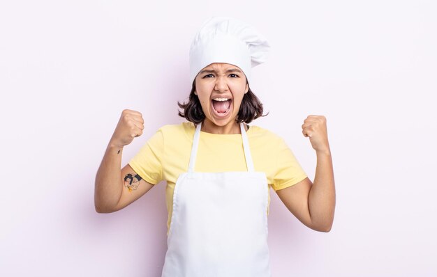 Bastante joven gritando agresivamente con una expresión de enojo. concepto de cocinero