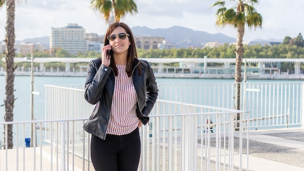 Bastante joven hablando por teléfono móvil en Málaga, un día soleado