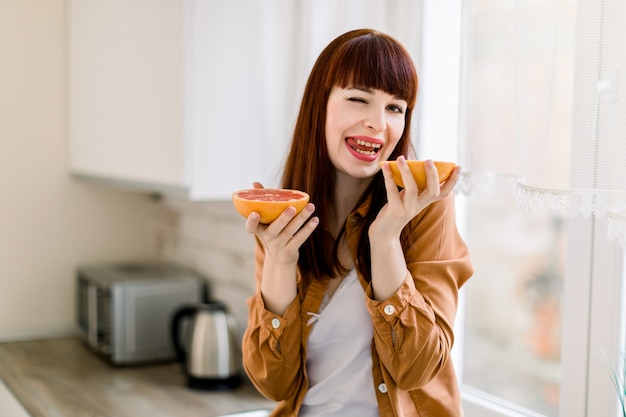 Bastante joven hermosa mujer de pelo rojo en camisa casual mostaza