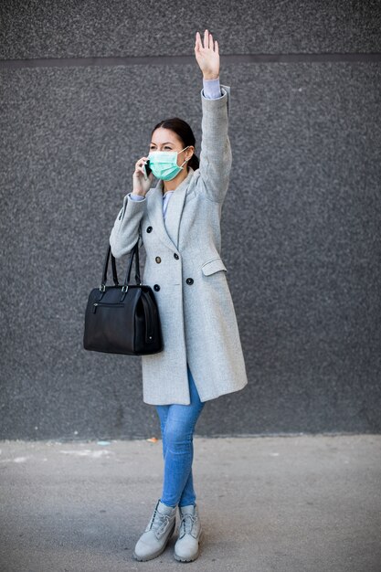 Bastante joven con máscara facial protectora en la calle