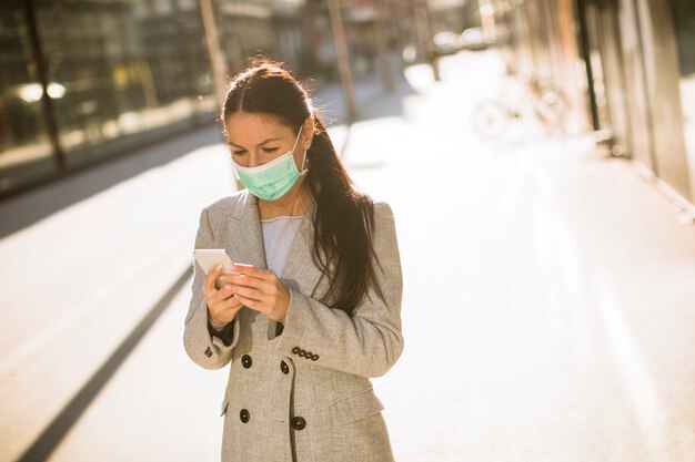 Bastante joven con máscara facial protectora en la calle