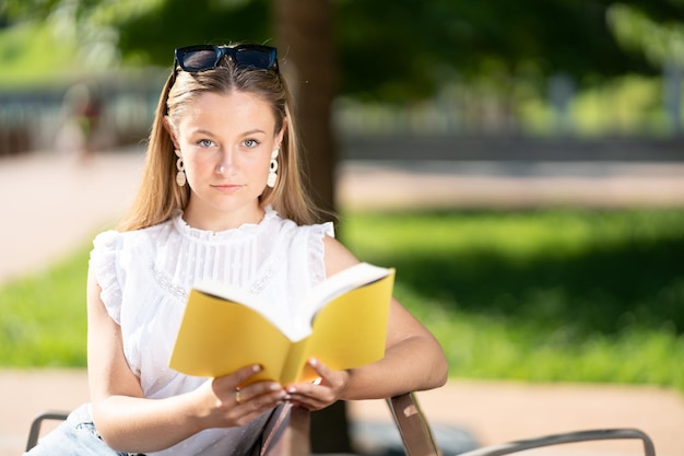 Bastante joven mirando a la cámara y sosteniendo el libro