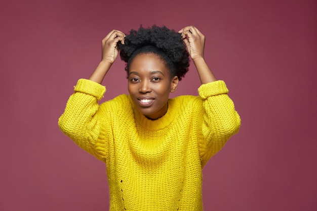 Bastante joven mujer afroamericana arreglar pelos afro cortos peinado acicalarse durante la rutina de belleza