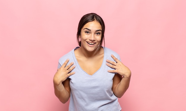 Bastante joven mujer feliz, sorprendida, orgullosa y emocionada