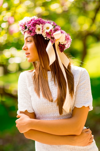 Bastante joven mujer con flores en el pelo en un día soleado de primavera