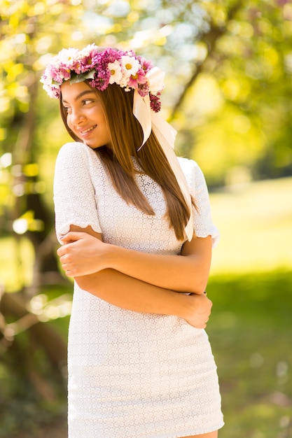 Bastante joven mujer con flores en el pelo en un día soleado de primavera