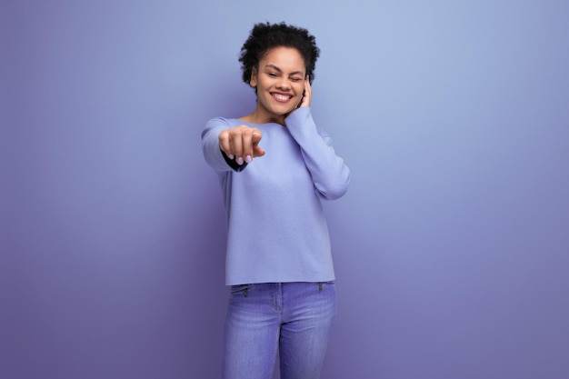 Bastante joven mujer latina con cabello afro en elegante ropa de primavera coqueteando