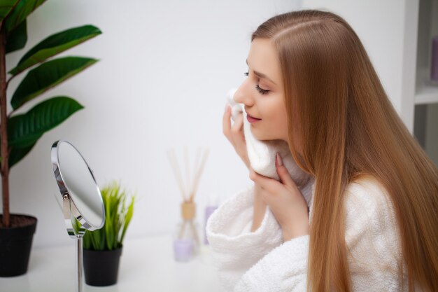 Bastante joven mujer mirando en el espejo después de una ducha