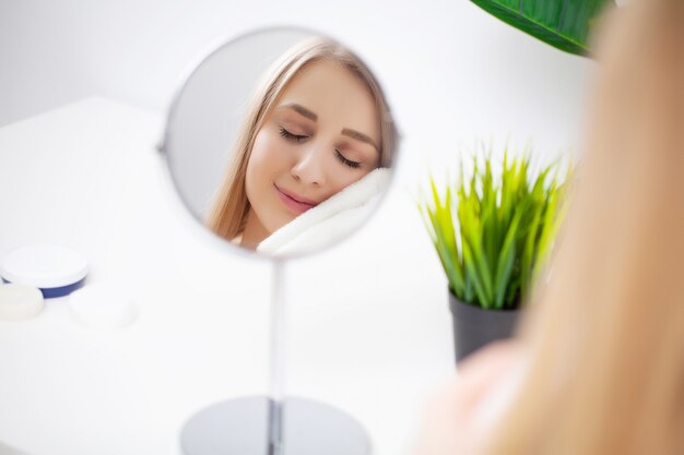 Bastante joven mujer mirando en el espejo después de una ducha