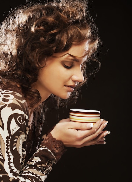 Bastante joven mujer tomando café