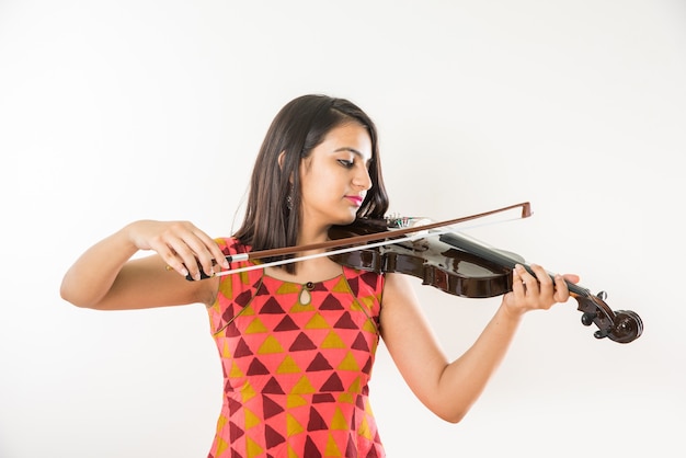 Bastante joven músico indio asiático tocando el violín contra el fondo blanco.