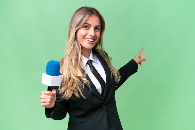 Foto bastante joven presentadora de televisión uruguaya sobre antecedentes aislados apuntando hacia atrás