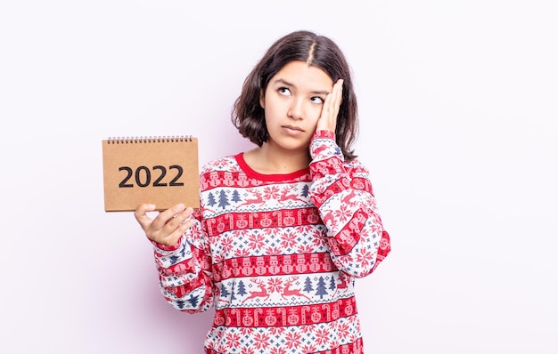 Bastante joven que se siente aburrida, frustrada y con sueño después de un cansancio. Concepto de calendario 2022