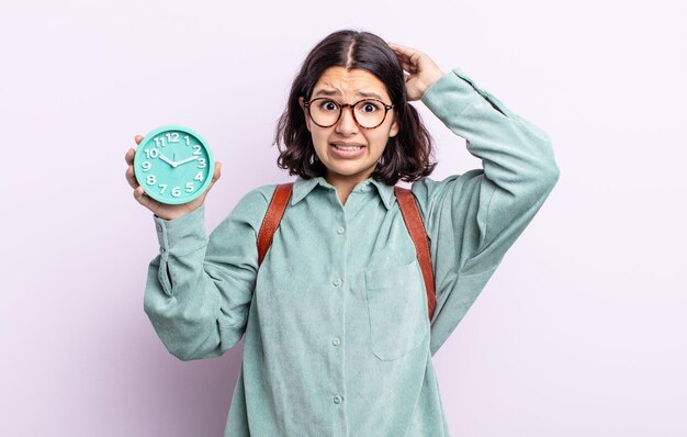 Bastante joven sentirse estresado, ansioso o asustado, con las manos en la cabeza. concepto de reloj despertador