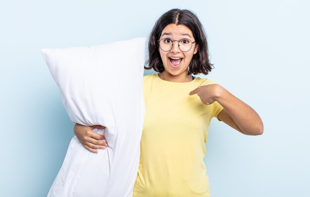 Bastante joven sintiéndose feliz y apuntando a sí mismo con un emocionado. concepto de cama