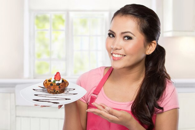 Bastante joven sirviendo muffin de chocolate