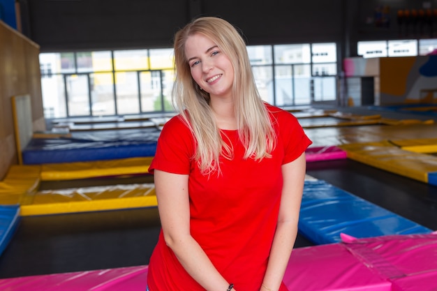 Bastante joven sonriendo en un trampolín en el interior