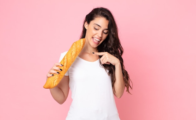 Bastante joven sosteniendo una baguette de pan