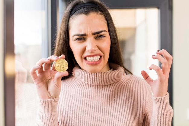 Foto bastante joven sosteniendo un diseño de interiores de casa bitcoin