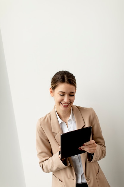 Bastante joven sosteniendo tableta digital en la oficina moderna