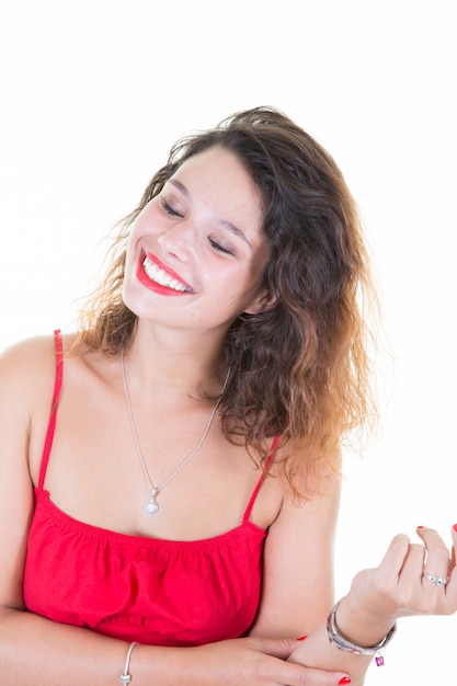 Bastante joven en vestido rojo feliz ríe con los ojos cerrados