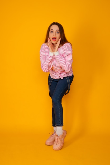 Bastante joven vistiendo una elegante camiseta rosa sobre fondo amarillo