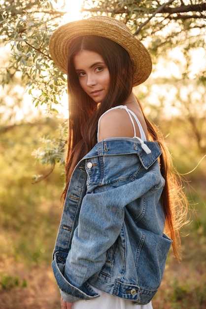 Bastante linda jovencita de pie al aire libre en el campo