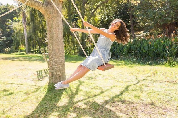 Bastante morena columpiándose en el parque