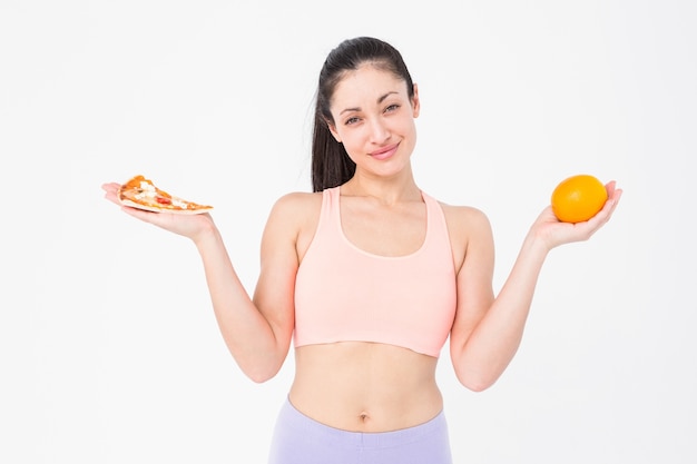 Bastante morena con pizza y naranja