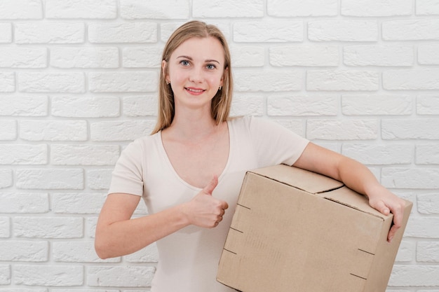 bastante, mujer joven, con, caja de cartón, entregar, un, paquete