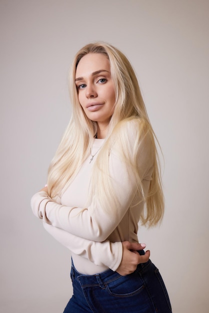 Bastante sonriente alegremente mujer con cabello rubio vestida casualmente mirando con satisfacción a la cámara b