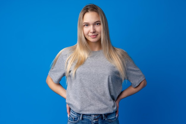 Bastante sonriente retrato de niña contra el fondo azul en el estudio.