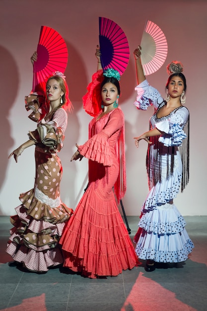 Foto bastante tres bailarín joven del flamenco en vestido hermoso.