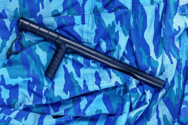 Bastão de borracha preto sobre a camuflagem da polícia de motim russa urbana azul