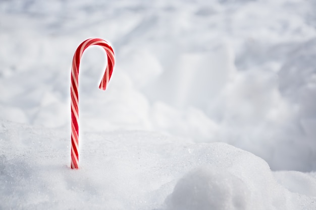 Bastão de hortelã-pimenta doce de Natal com espaço de fundo de queda de neve para texto