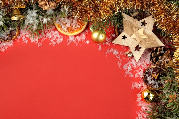 Bastidor con un árbol de Navidad y adornos de colores sobre un fondo rojo brillante