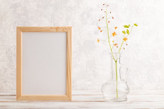 Bastidor de madera con flores de barrenwort naranja en vidrio sobre fondo de hormigón gris espacio de copia