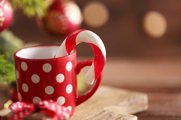 Bastões de doces de Natal na xícara com decoração de Natal na mesa