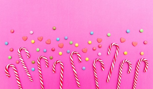 Foto bastões de doces no espaço de cópia de fundo rosa