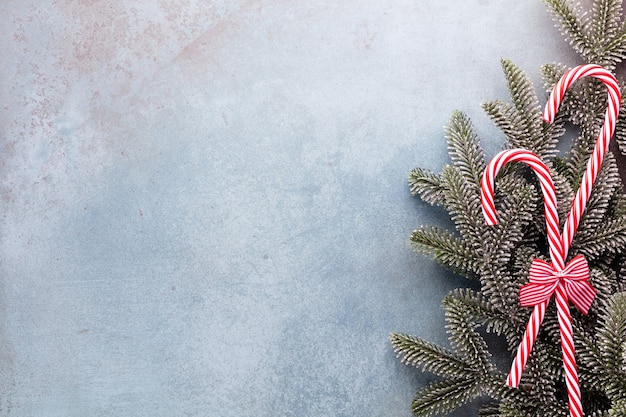 Foto bastón de caramelo de navidad mintió uniformemente en fila sobre fondo azul.