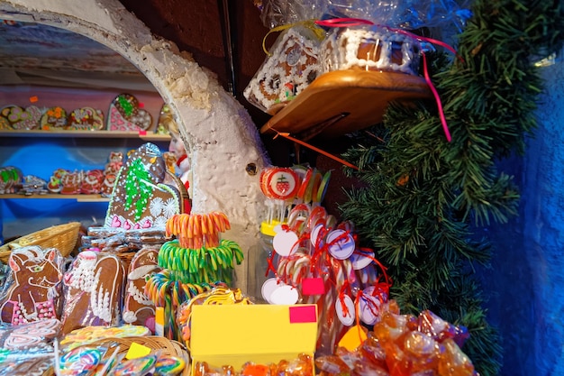 Bastones de caramelo y corazones y casas de pan de jengibre exhibidos en un mercado navideño europeo tradicional en Riga, Letonia