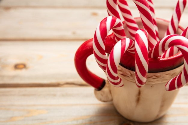 Bastones de caramelo en un espacio de copia de fondo de madera de taza de navidad