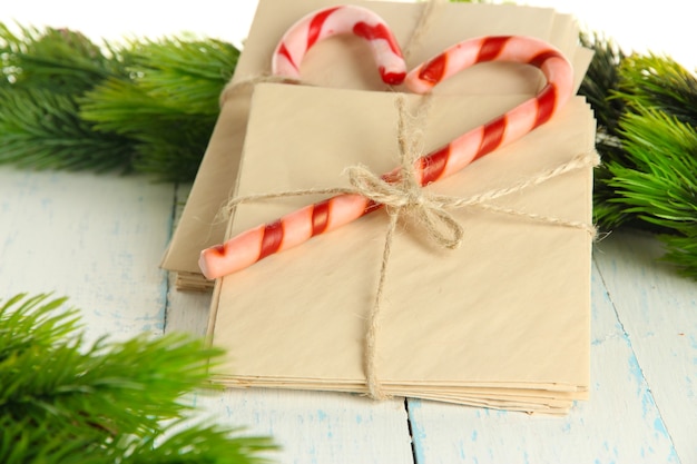 Bastones de caramelo de Navidad y cartas para Santa, sobre fondo de madera de color