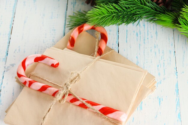 Bastones de caramelo de Navidad y cartas para Santa, sobre fondo de madera de color